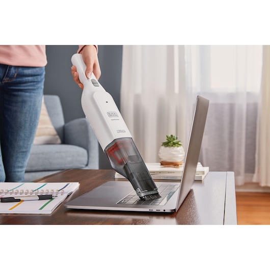 BLACKDECKER HLVC315J11 handstofzuiger reinigt laptoptoetsenbord in huiselijke omgeving.