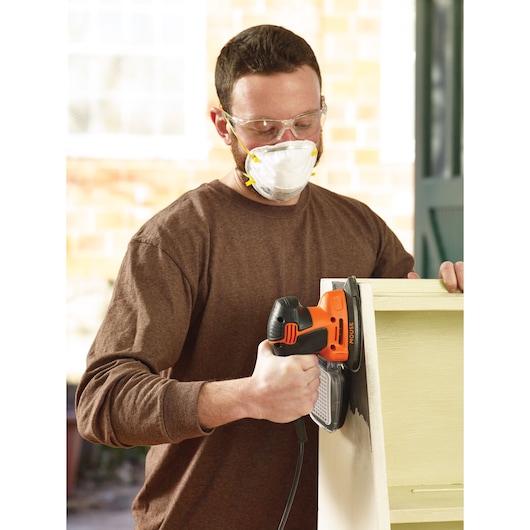 BLACKDECKER KA2000 ponceuse mouse utilisée sur une étagère en bois, photographie du produit tenu par une personne.