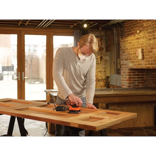 BLACKDECKER KA450 schuurmachine op houten deur in werkplaats.