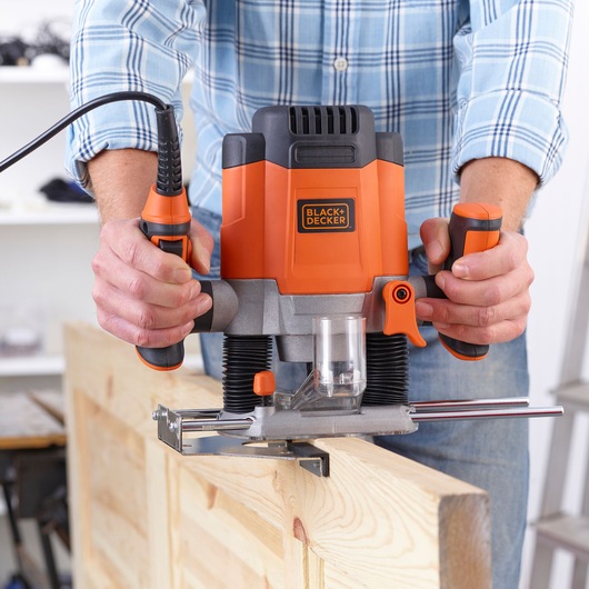 Photo de la défonceuse BLACK+DECKER KW1200E utilisée sur une planche en bois, vue rapprochée.