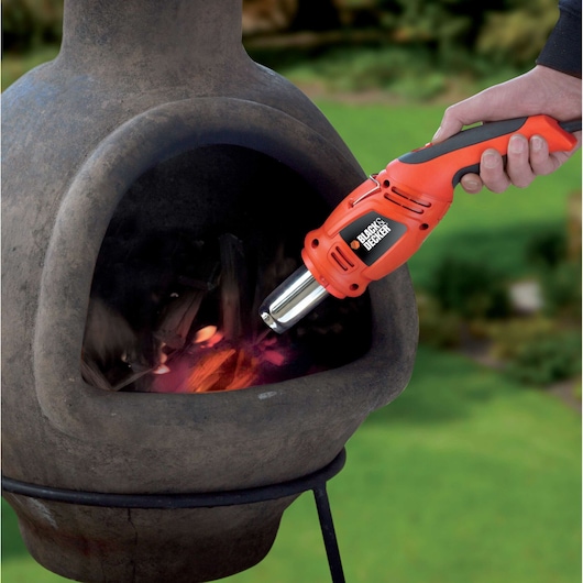 BLACKDECKER KX1692 heteluchtpistool gebruikt om hout in buitenhaard aan te steken, close-up.