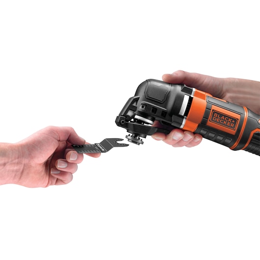 Foto van BLACKDECKER MT300KA multitool zijaanzicht, hand bevestigt accessoireblad