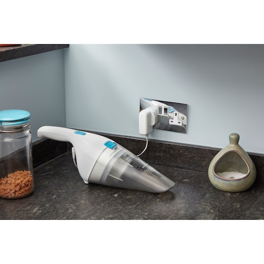 BLACKDECKER NVC115JL aspirateur à main en charge sur le plan de travail de cuisine, vue latérale.