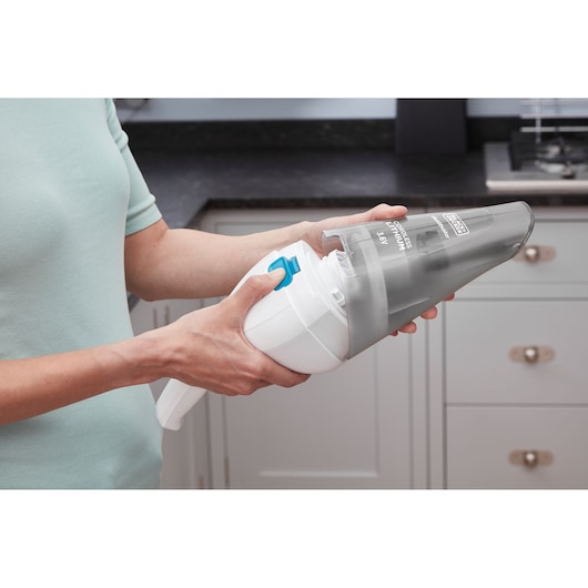 Photo de l’aspirateur à main BLACKDECKER NVC115JL ouvert pour nettoyage dans une cuisine.