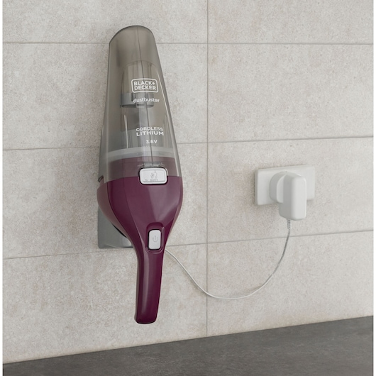 BLACKDECKER NVC115W draadloze handstofzuiger aan de muur gemonteerd, opgeladen met een witte adapter.