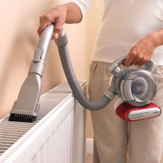 BLACKDECKER PD1020L aspirateur à main nettoyant un radiateur avec tuyau flexible et brosse.
