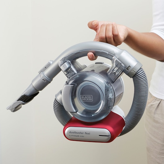 Aspirateur à main BLACK+DECKER PD1020L avec flexible gris et base rouge, tenu dans la main.