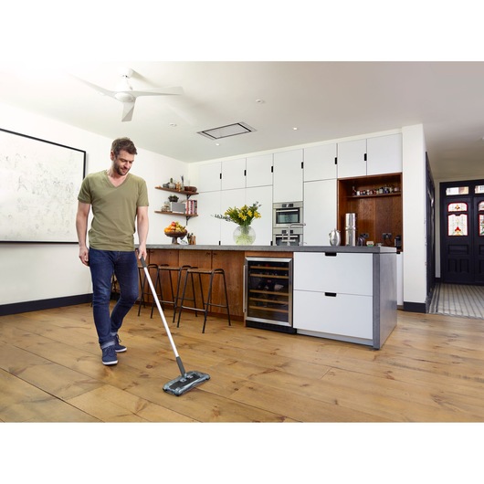 BLACKDECKER PSA215B draadloze vloerwisser gebruikt op houten keukenvloer.