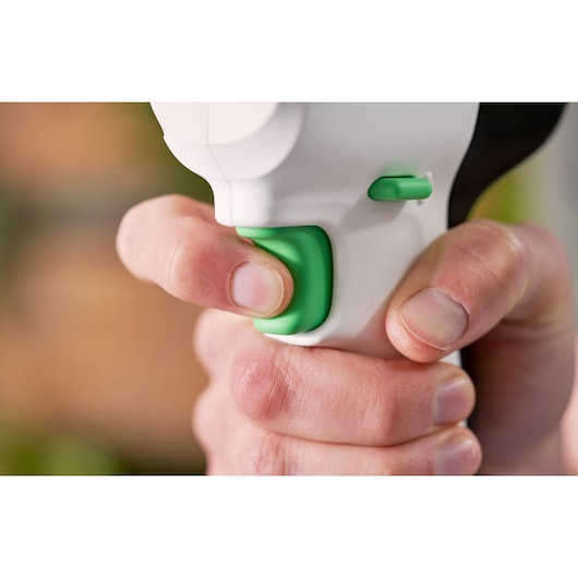 BLACKDECKER REVDD12C perceuse gros plan avec gâchette et bouton vert dans une main.
