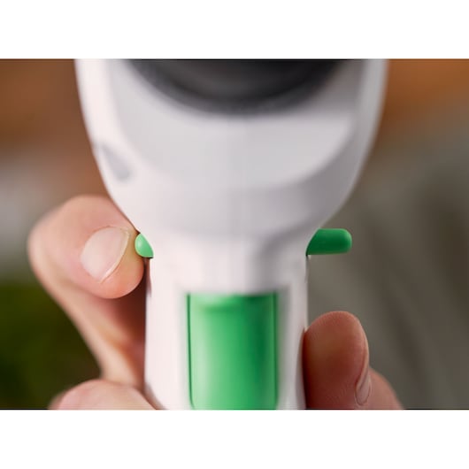 Photo en gros plan de la poignée blanche et verte de l’outil BLACKDECKER REVDD12C avec boutons de gâchette.