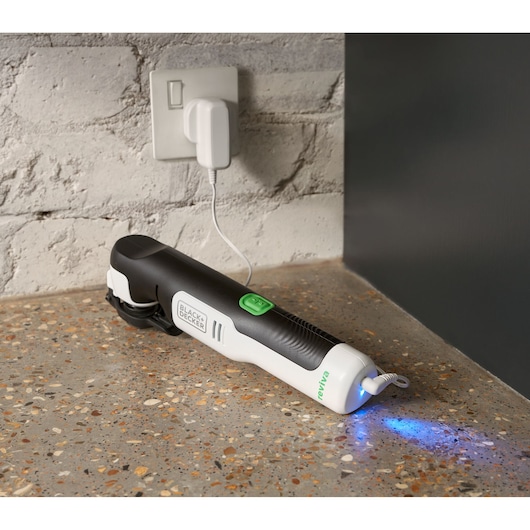 BLACK+DECKER REVOS12C elektrische wijnopener met groene knop aan het opladen op aanrecht, blauwe LED brandt.