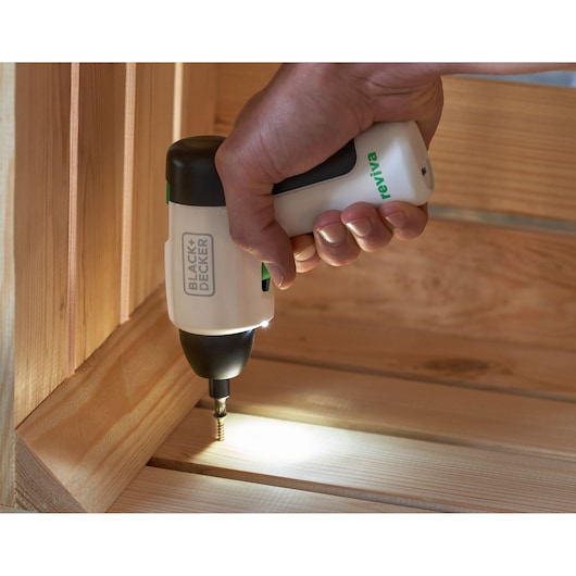 Photo du tournevis sans fil BLACK+DECKER REVSD4C avec lumière LED, utilisé pour visser dans des planches en bois.