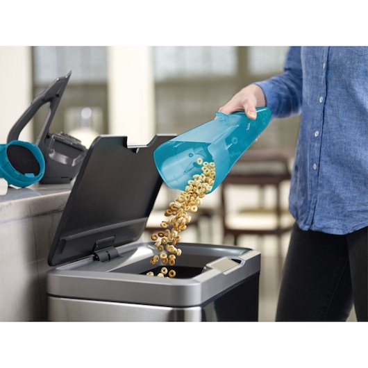 BLACKDECKER WDA320J handstofzuiger stofreservoir geleegd in prullenbak, close-up binnen.