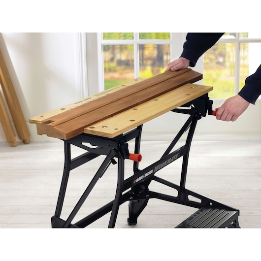 BLACK+DECKER WM626 établi avec plateau en bois clair tenant des planches, intérieur, vue latérale.