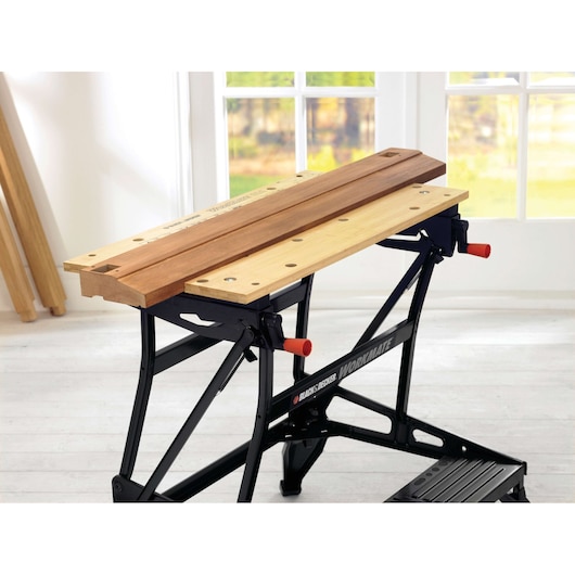 BLACK+DECKER WM626 établi pliant avec un étau en bois et un cadre en acier noir, présenté en angle à l'intérieur.